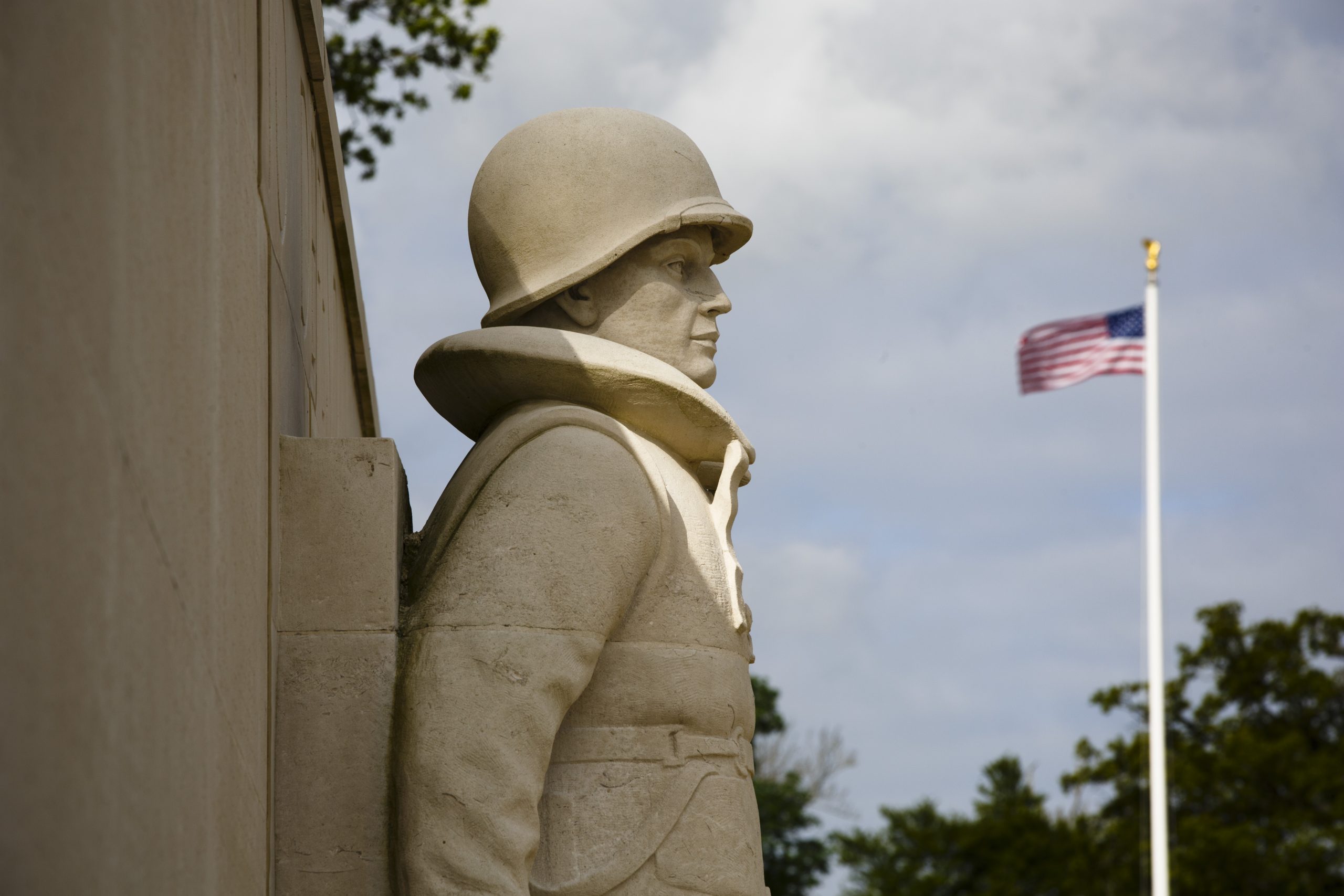 Picture of Cambridge American Cemetery with the U.S. flag in the background. Credit: American Battle Monuments Commission/ Page.