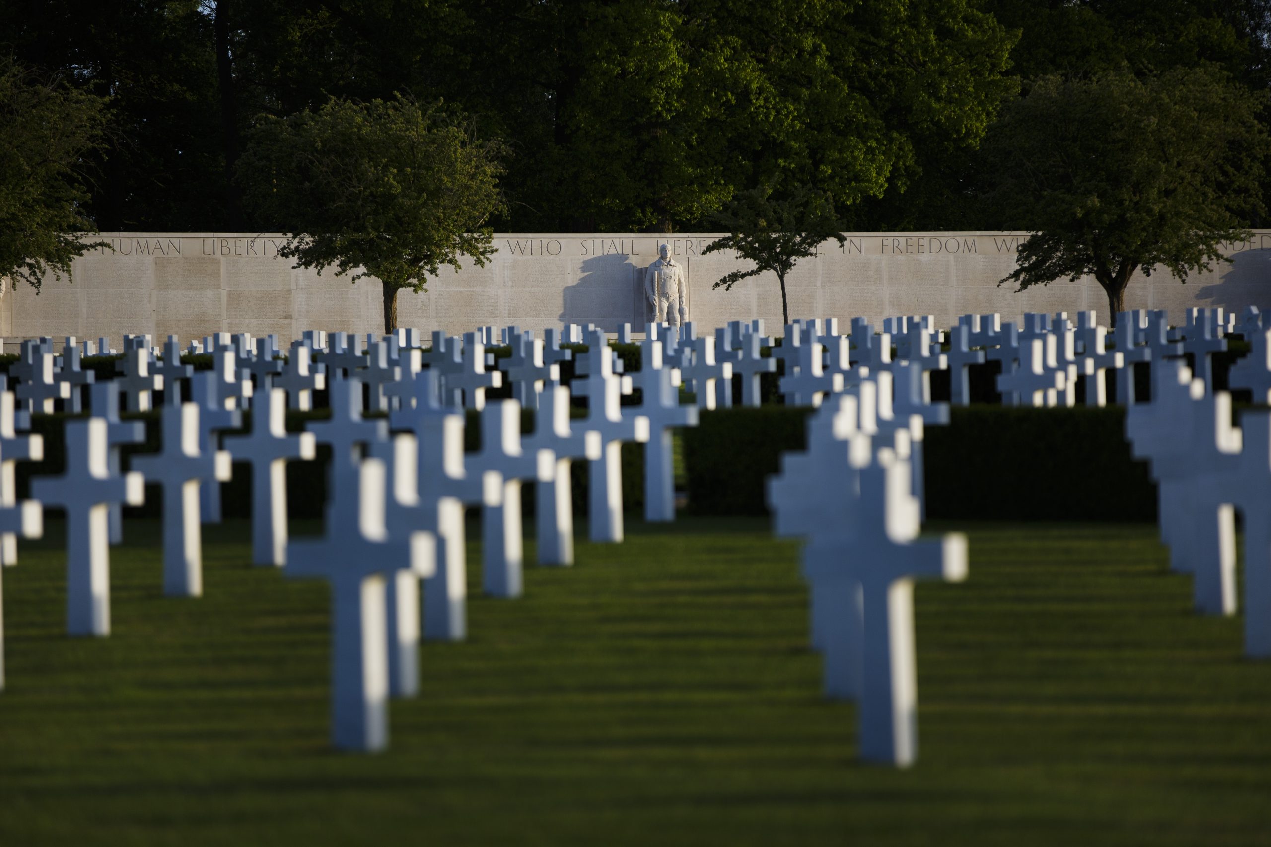 View of Cambridge American Cemetery with rows of white crosses and the wall of the missing as seen at the Cambridge American Military Cemetery, in Cambridge, England