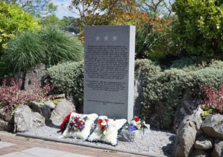Square floral wreaths sit at the base of the new monument.