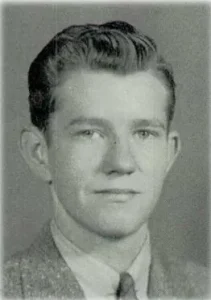 A black and white headshot of Pfc. John Chappell in a suit.
