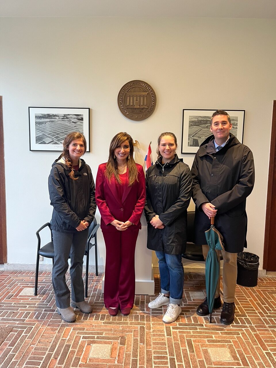 ABMC International Fellows Anaiya Harris and Catherine Prince pose with Shefali Razdan Duggal, U.S. Ambassador to the Netherlands, and Jason Bordelon, NEAC Superintendent. The two Air Force ROTC cadets had the chance to meet the ambassador during their fellowship at the site learning about its operation and assisting with their annual Memorial Day ceremony. Credits: American Battle Monuments Commission. ABMC International Fellows Anaiya Harris and Catherine Prince pose with Shefali Razdan Duggal, U.S. Ambassador to the Netherlands, and Jason Bordelon, NEAC Superintendent. The two Air Force ROTC cadets had the chance to meet the ambassador during their fellowship at the site learning about its operation and assisting with their annual Memorial Day ceremony. Credits: American Battle Monuments Commission.