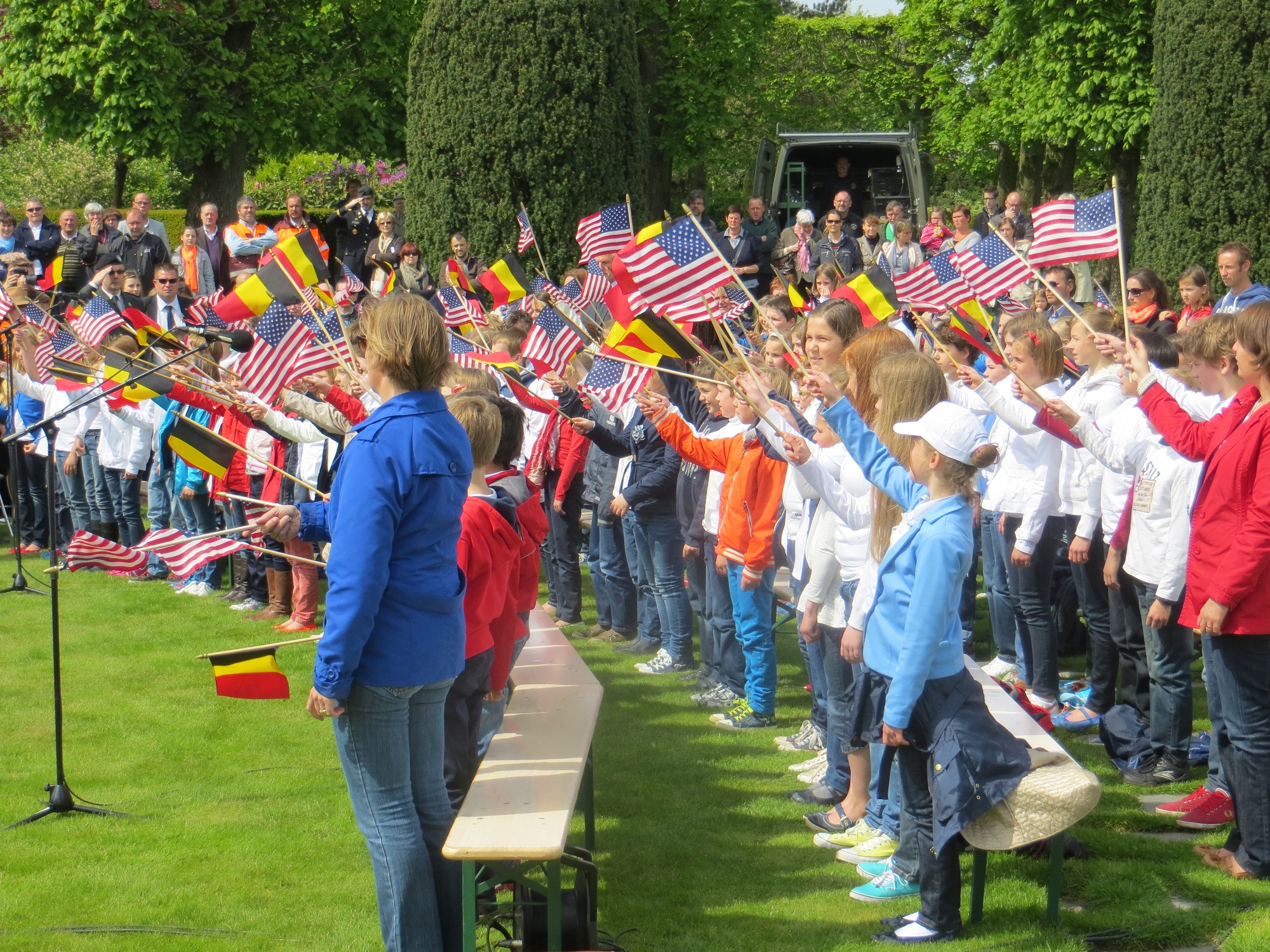 Local Belgian school children wave flags during the 2013 Memorial Day ceremony at Flanders Field American Cemetery.