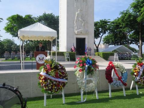 A man in a suit delivers remarks from the podium.
