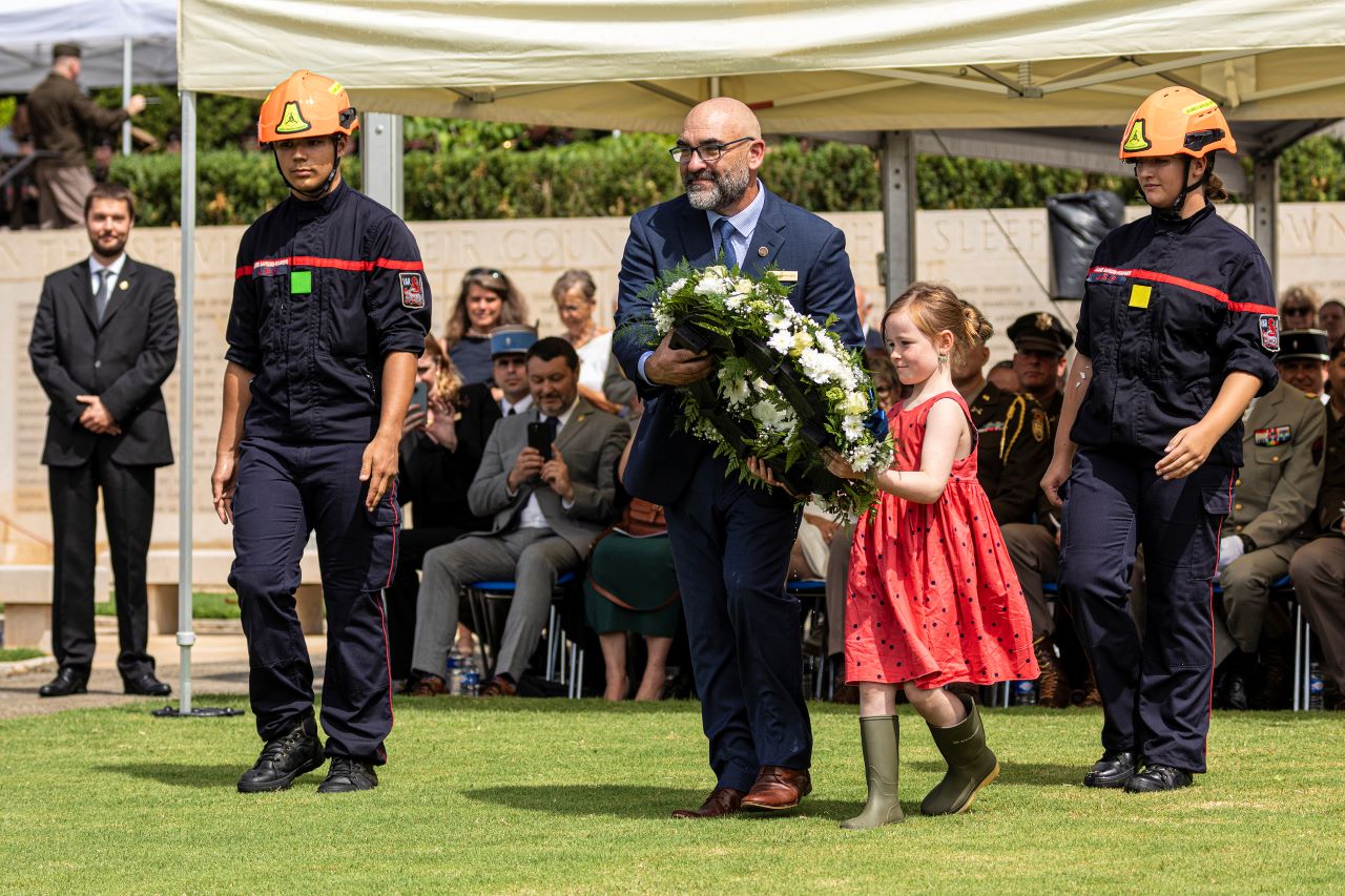 Commemorating Operation Dragoon The cemetery superintendent and his daughter carry a wreath to place during the ceremony