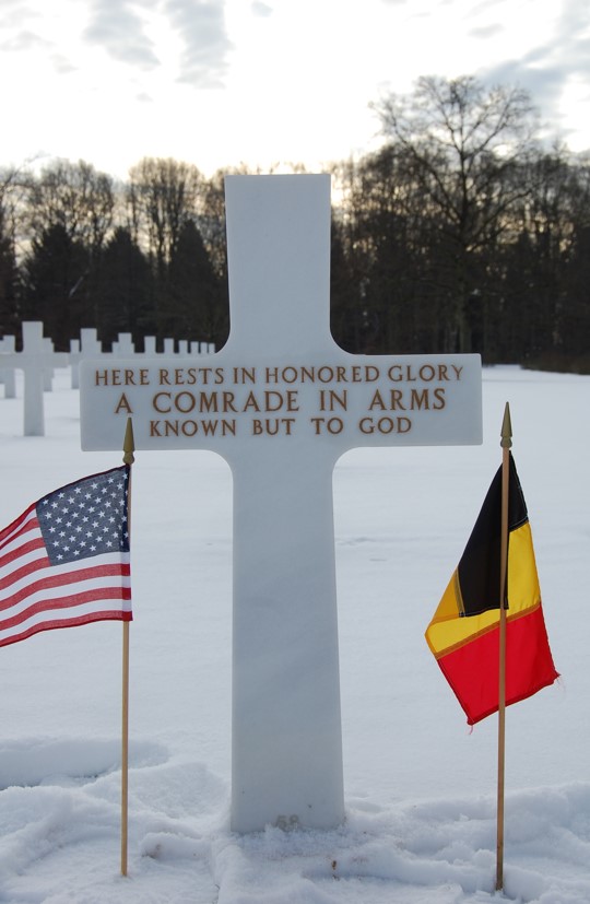 Unknown headstone under the snow with U.S. and Belgian flags. Credits: American Battle Monuments Commission. Unknown headstone under the snow with U.S. and Belgian flags. Credits: American Battle Monuments Commission.