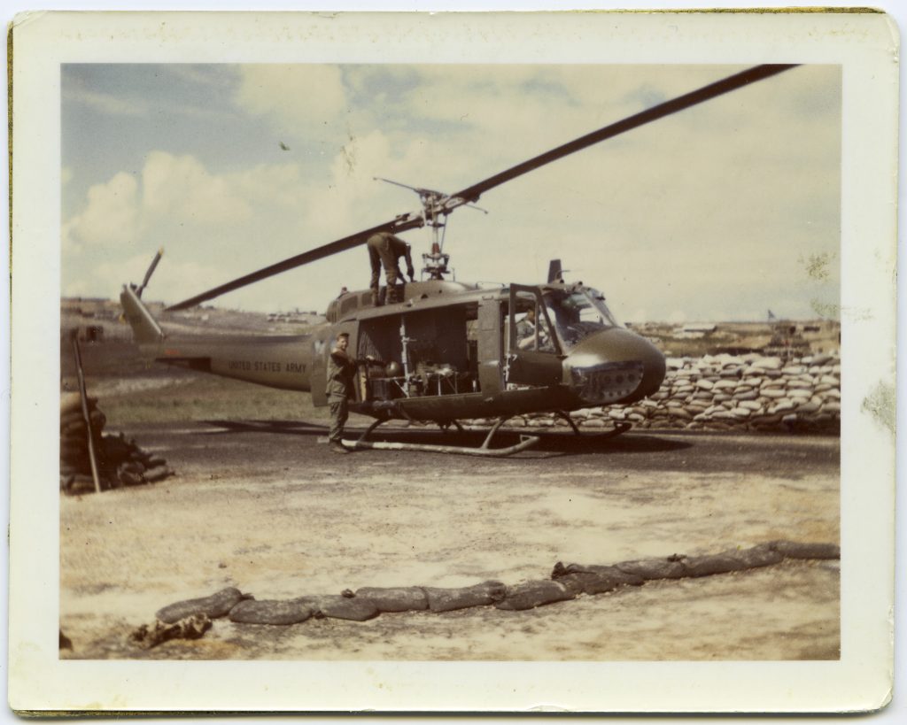 HU-1 (Huey) helicopter with the gunner putting the barrel on an M-60 machine gun at Camp Evans in Vietnam, December 4, 1968
