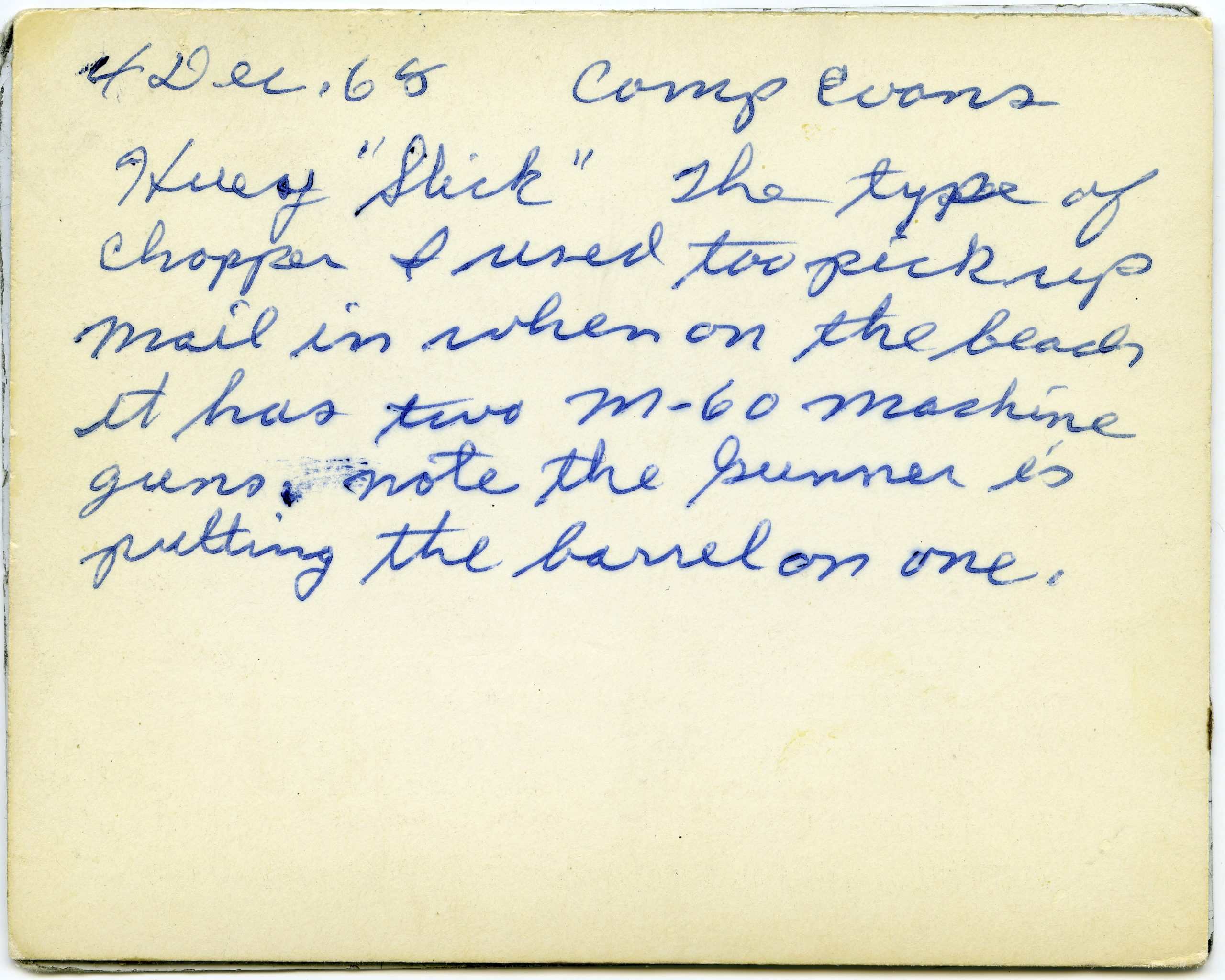 Handwritten note on the back of the photograph on the left  reads, “Huey ‘Slick’ the type of chopper I used too [sic] pick up mail in when on the beach/ it has two M-60 machine guns. note the Gunner is putting the barrel on one,” December 4, 1968.