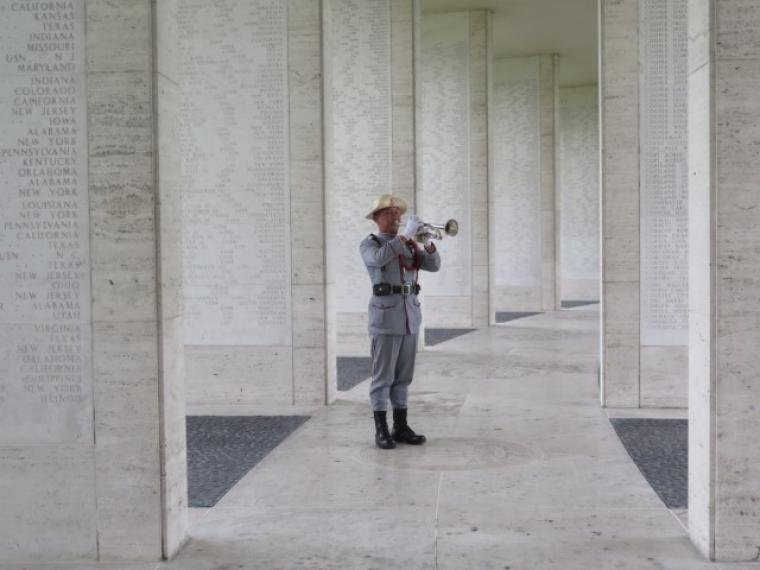A member of the Filipino military plays the bugle amidst the Walls of the Missing at Manila American Cemetery during the 2016 Veterans Day Ceremony.