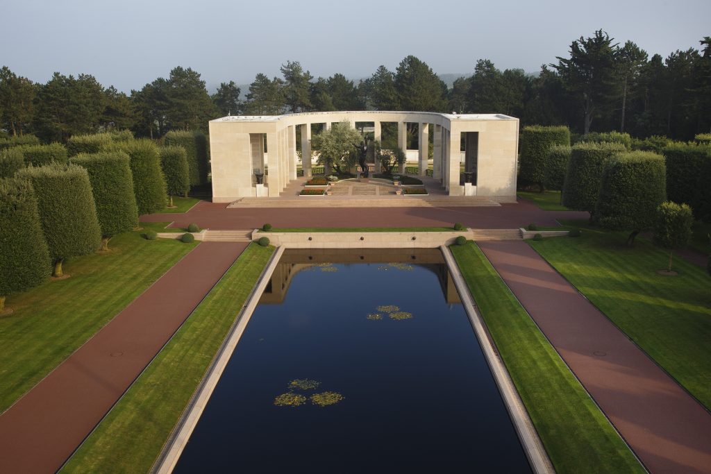 Picture of Normandy American Cemetery with one U.S. flag and the headstones. Credit: American Battle Monuments Commission/ Robert Uth.
